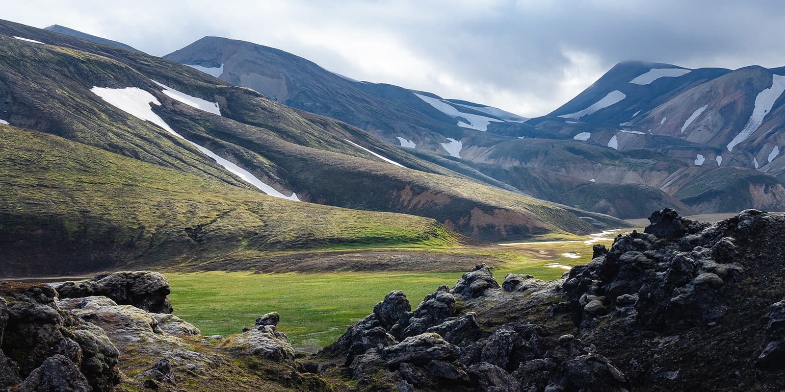 rolling hills of Iceland with snow capped peaks in background