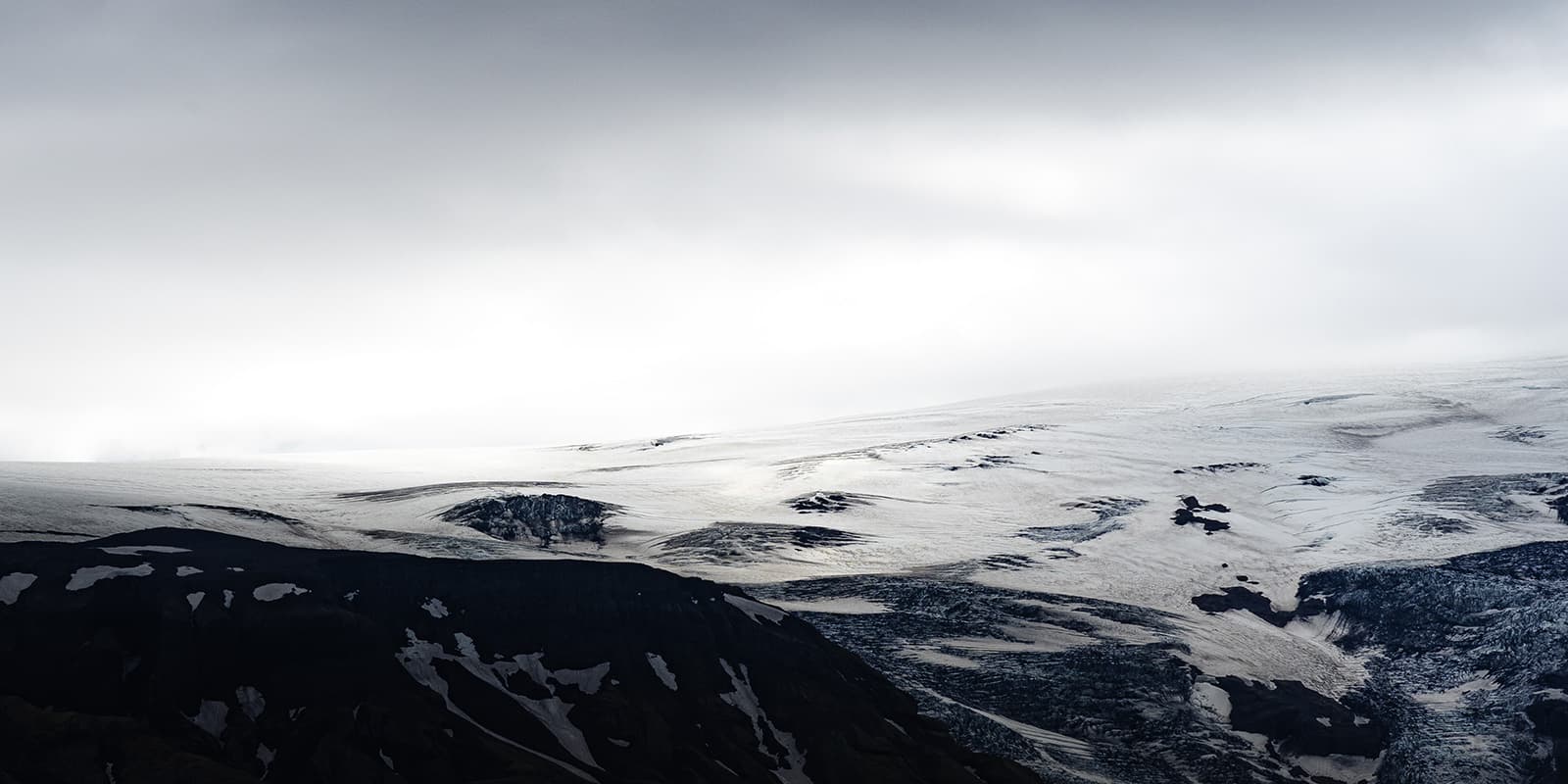 dramatic black and white photo of snow covered mountain peak