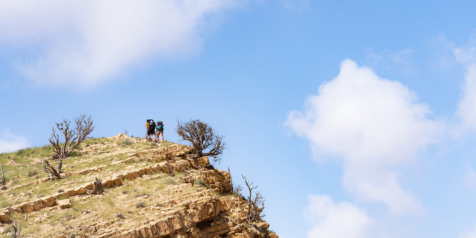 two persons hiking up mountain in Jordan desert