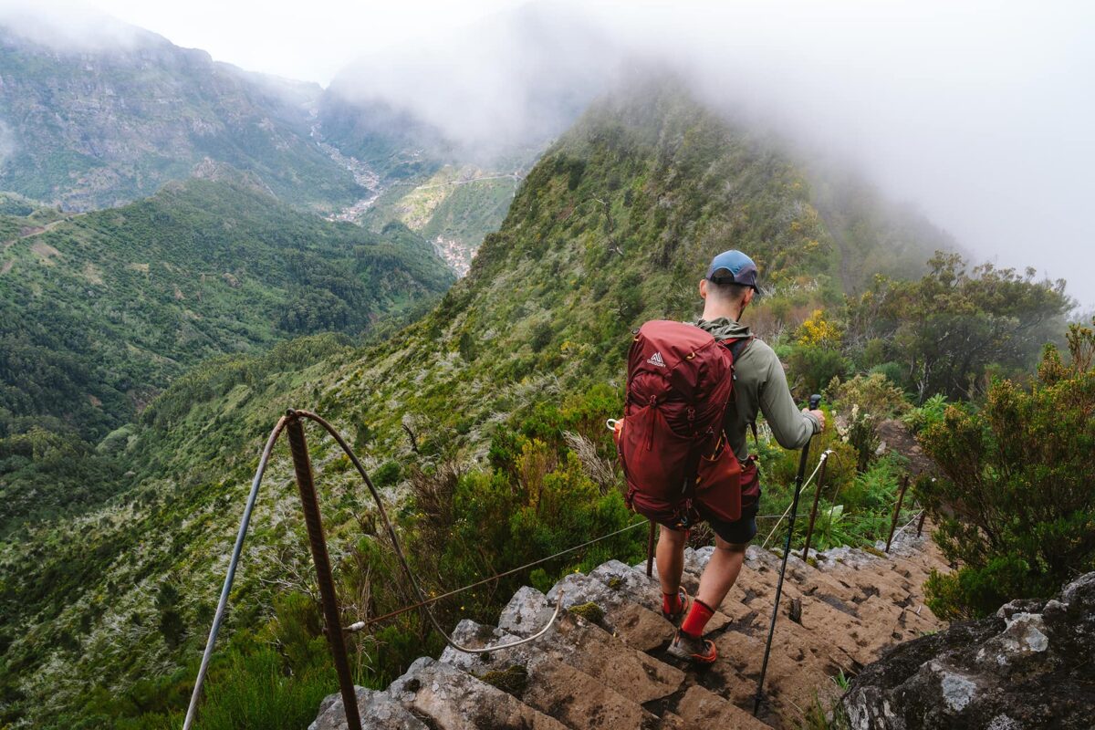 person hiking down steep staircase in the mountains