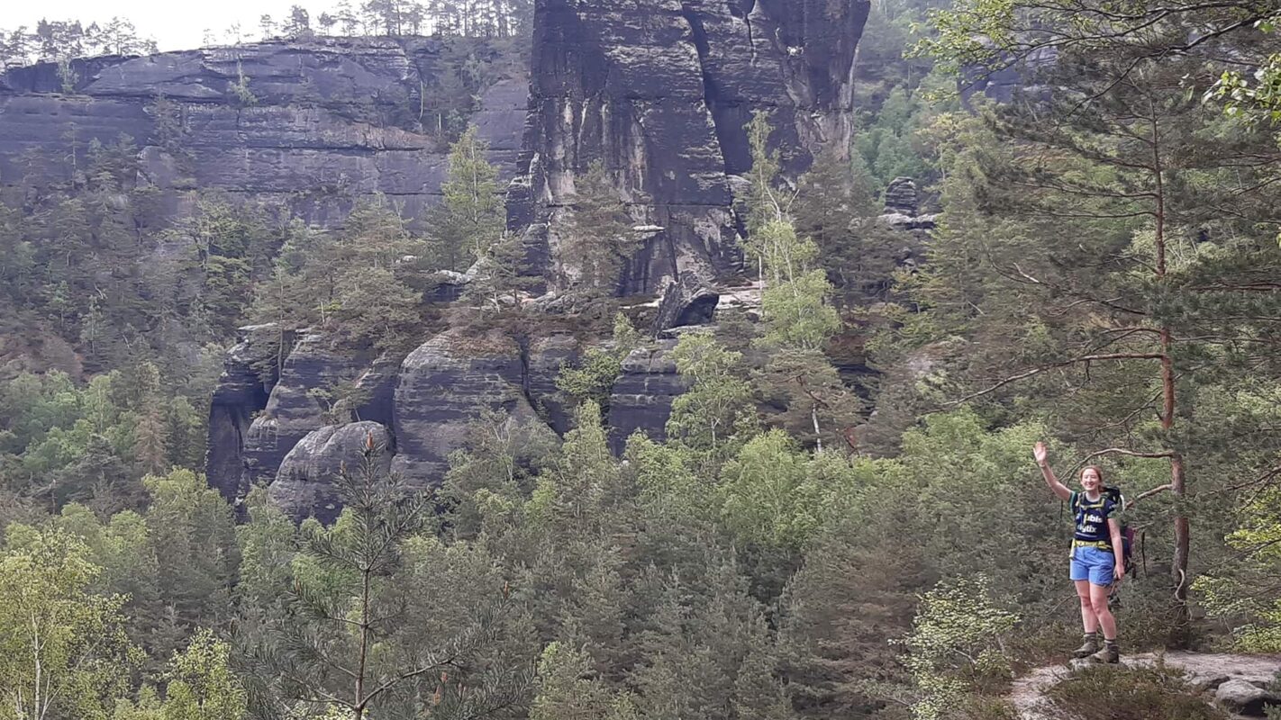 women waving while hiking outdoors in the forest