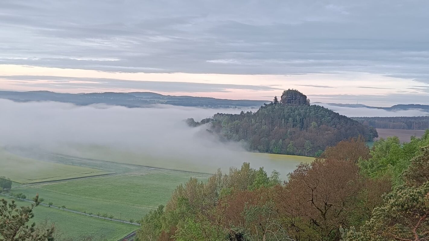 panoramic view of green landscape while clouds come in