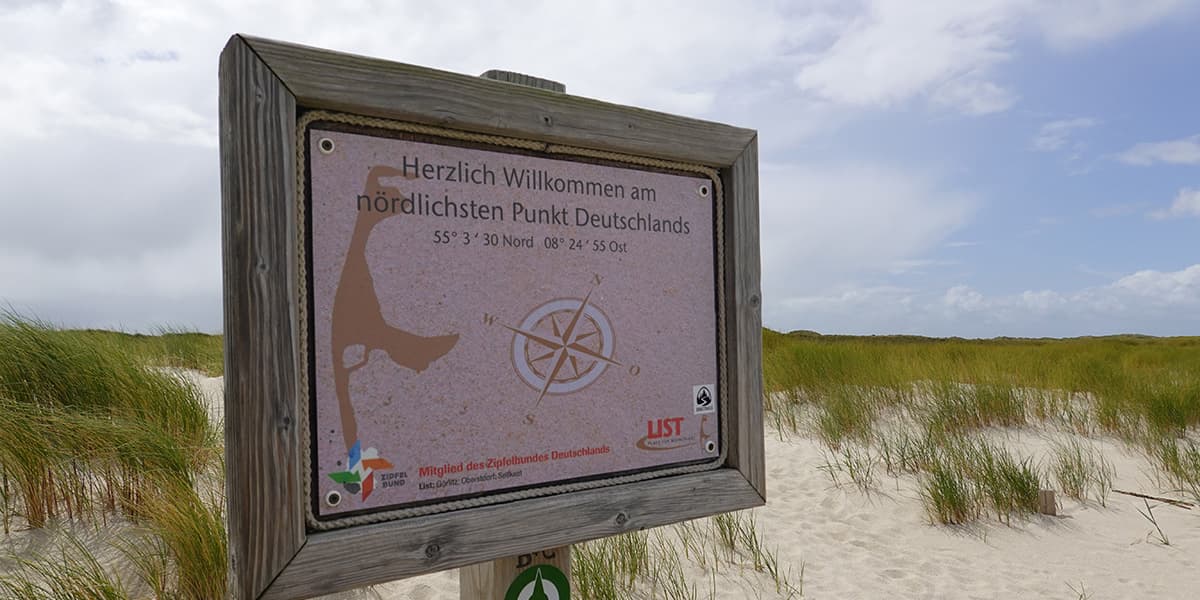 wooden sign at dune with grass