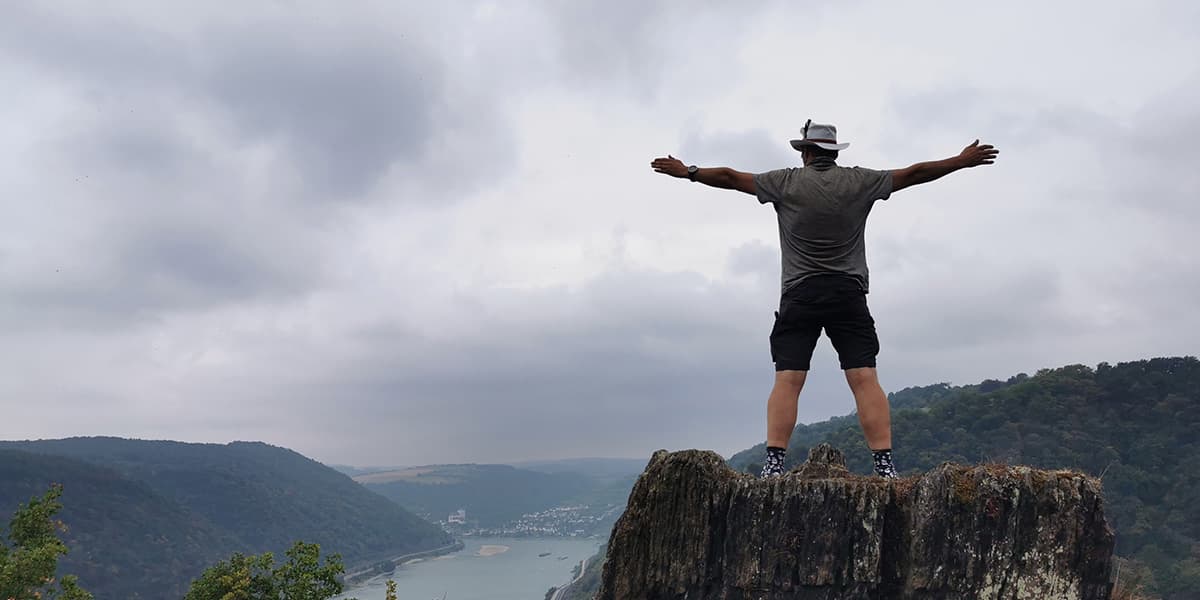 person standing on rock with his arms wide