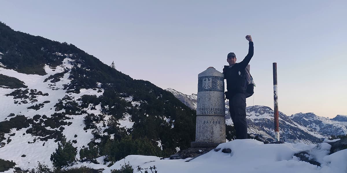 person cheering at pilar in snow covered mountains