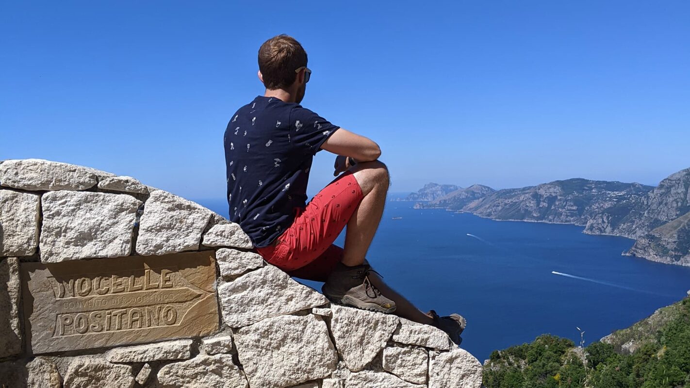 man sitting on rock overlooking the ocean near Positano