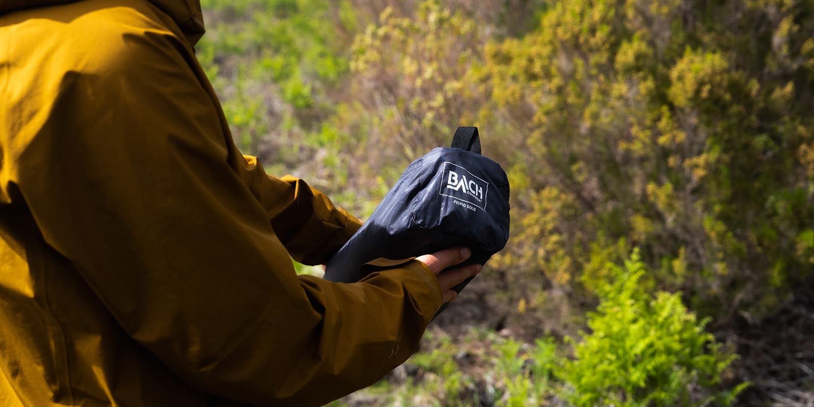 person holding packed tent