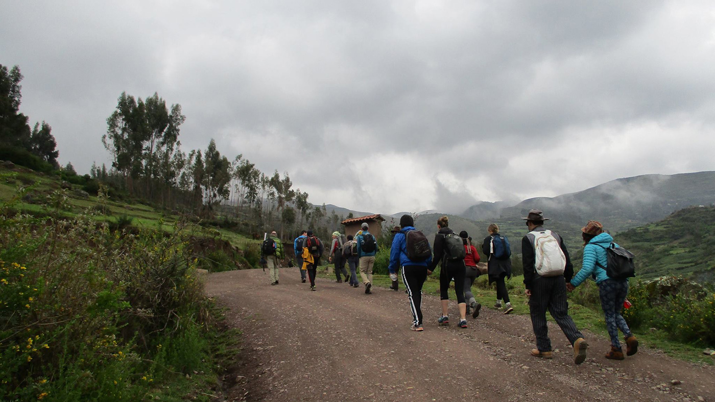 big group of people hiking up gravel road in het mountains of Peru