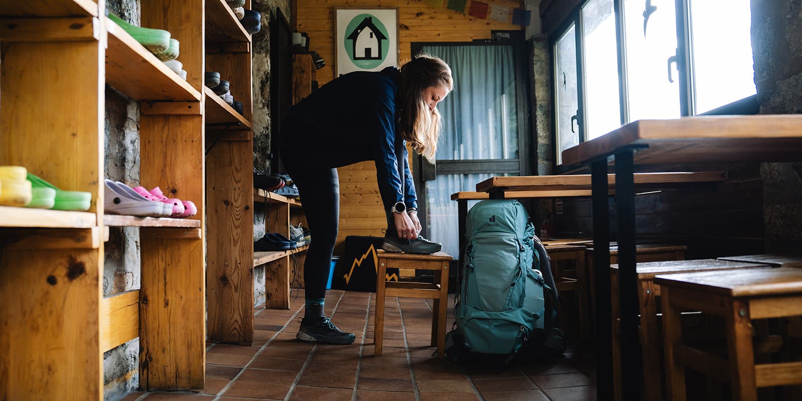 women getting tying her shoes in mountain hut