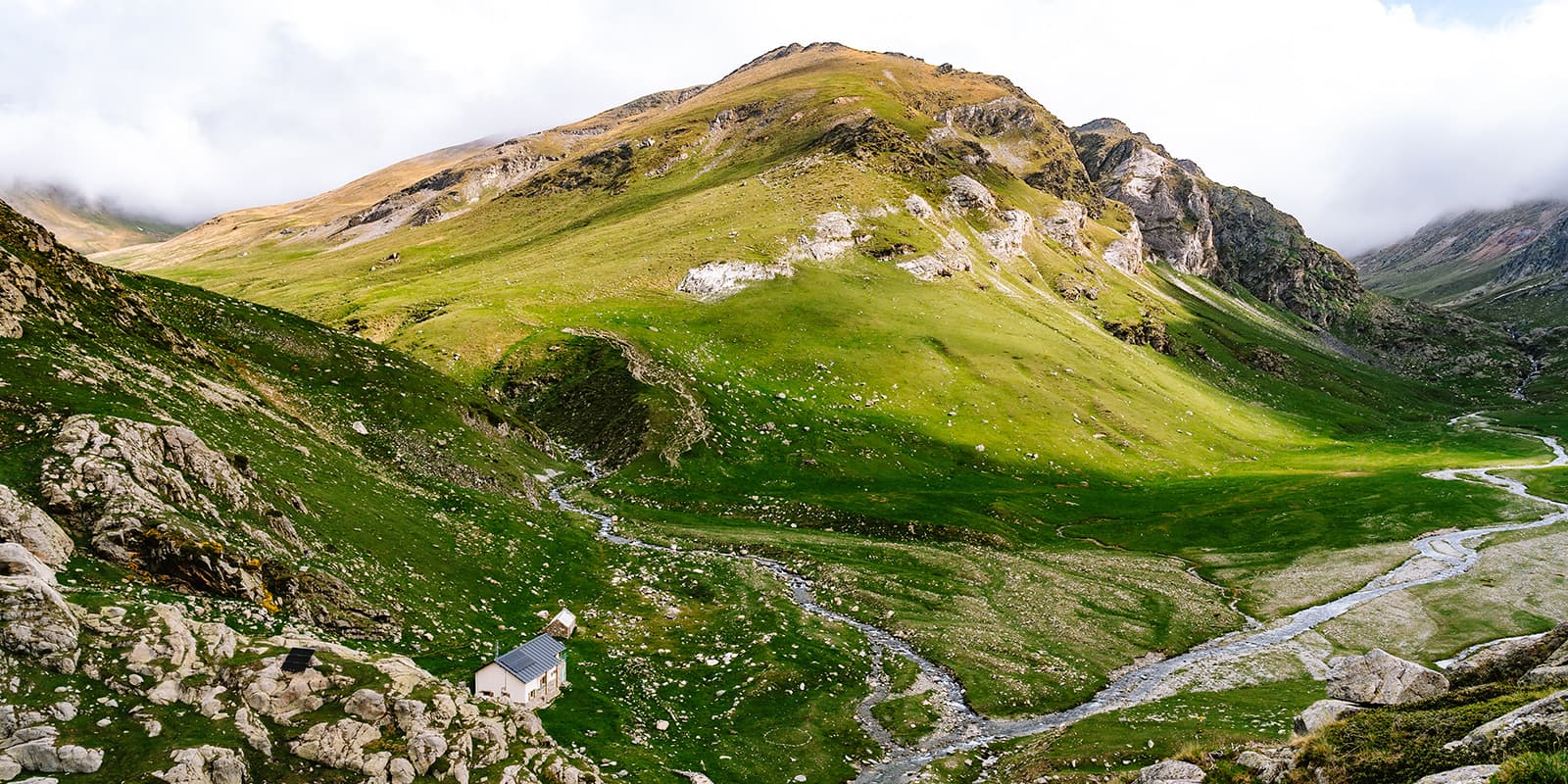 mountain hut in next to mountain and river