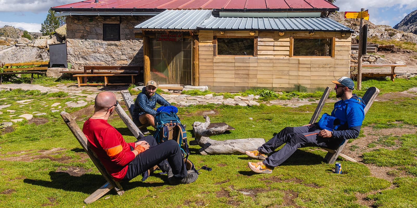 three men sitting outside in the mountains