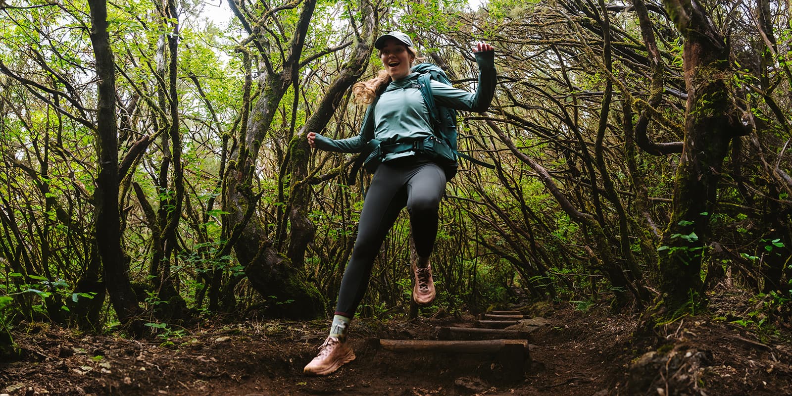 women jumping down forest path