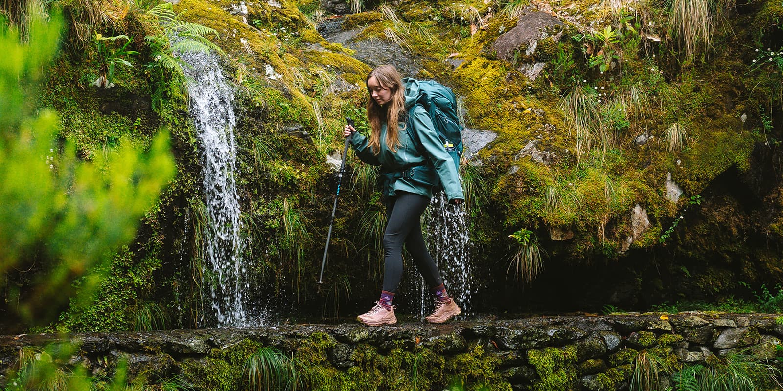 women hiking near waterfall