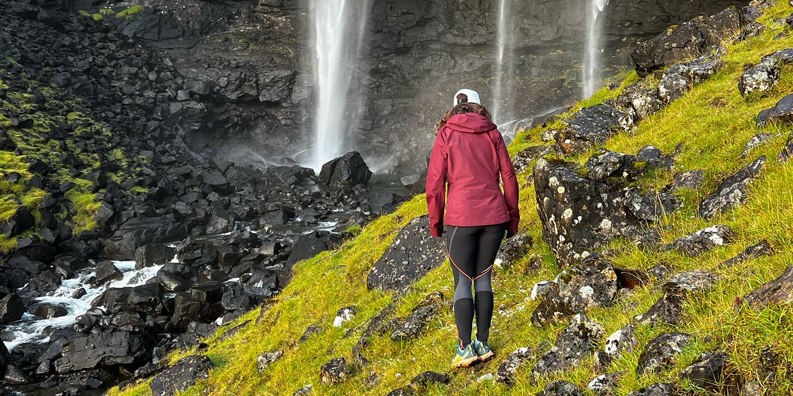 women standing near waterfall