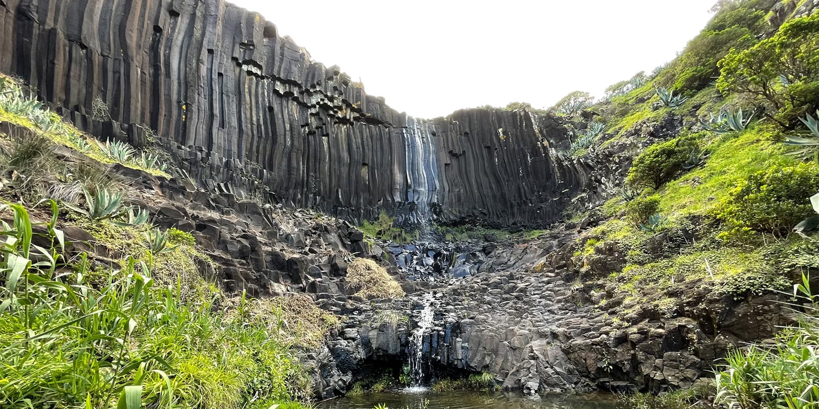 small waterfall near rocky hills on the azores