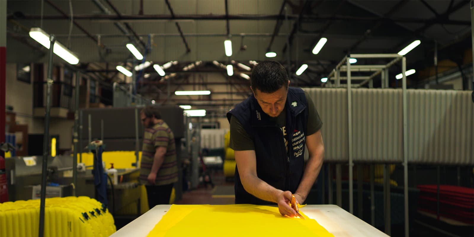 man trimming sleeping pad on MSR and Therma-Rest factory floor