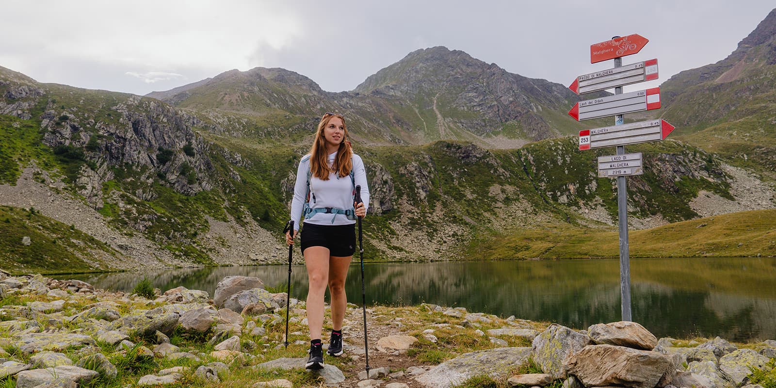 women hiking in alpine landscape near lake