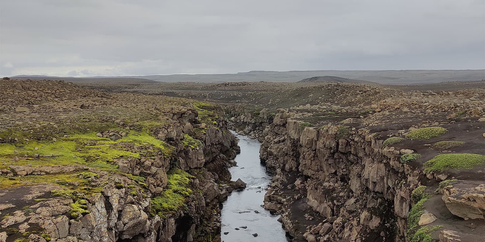 river running through canyon in iceland