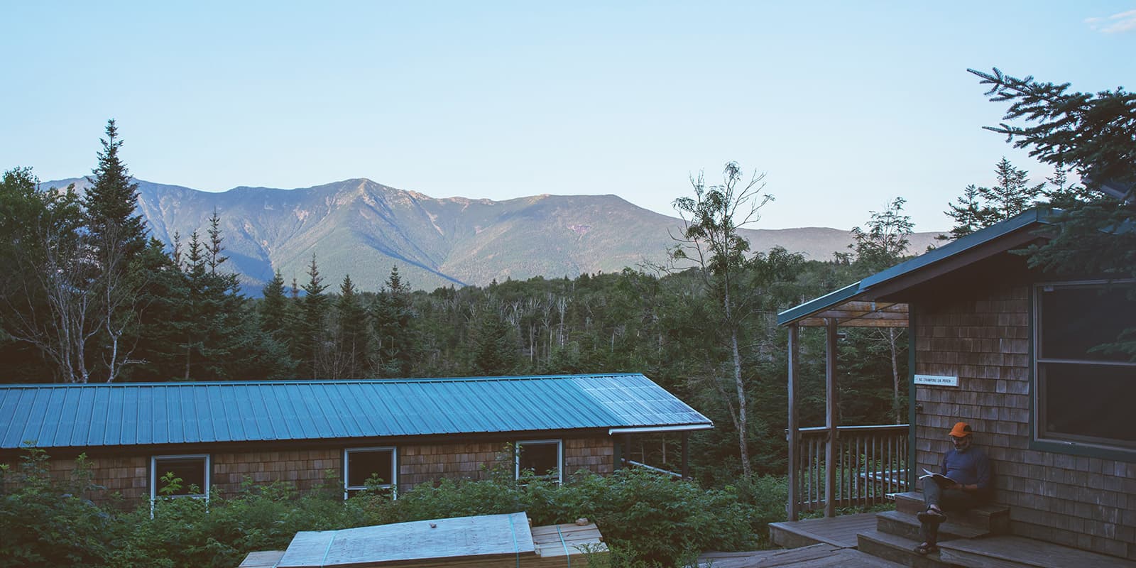 man reading on steps of the Lonesome lake hut