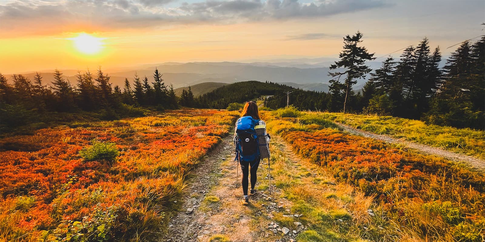 women hiking down colorful hills during sunrise on the Czech Trail