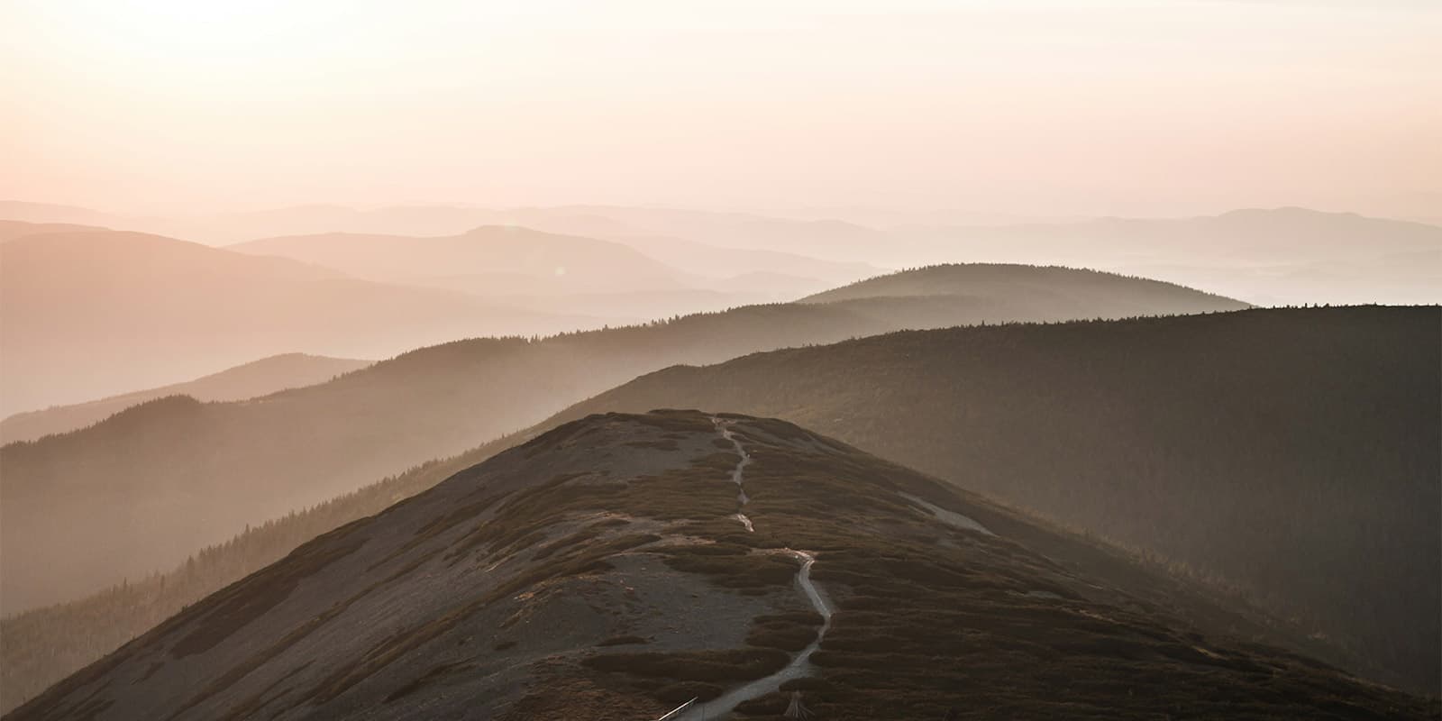 hiking trail passing over hills in sunset