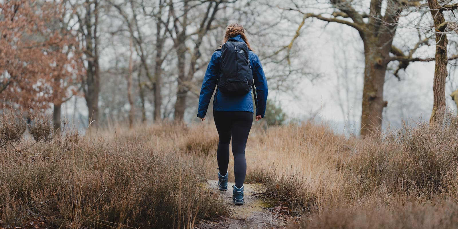 person hiking in grassy dunes