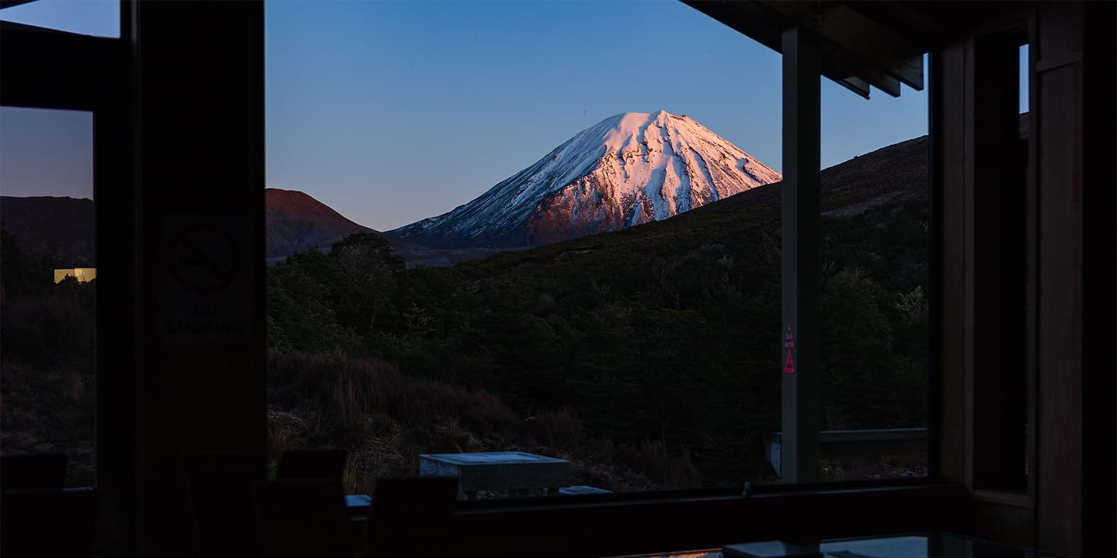 snowy peak during sunrise seen from a mountain hut