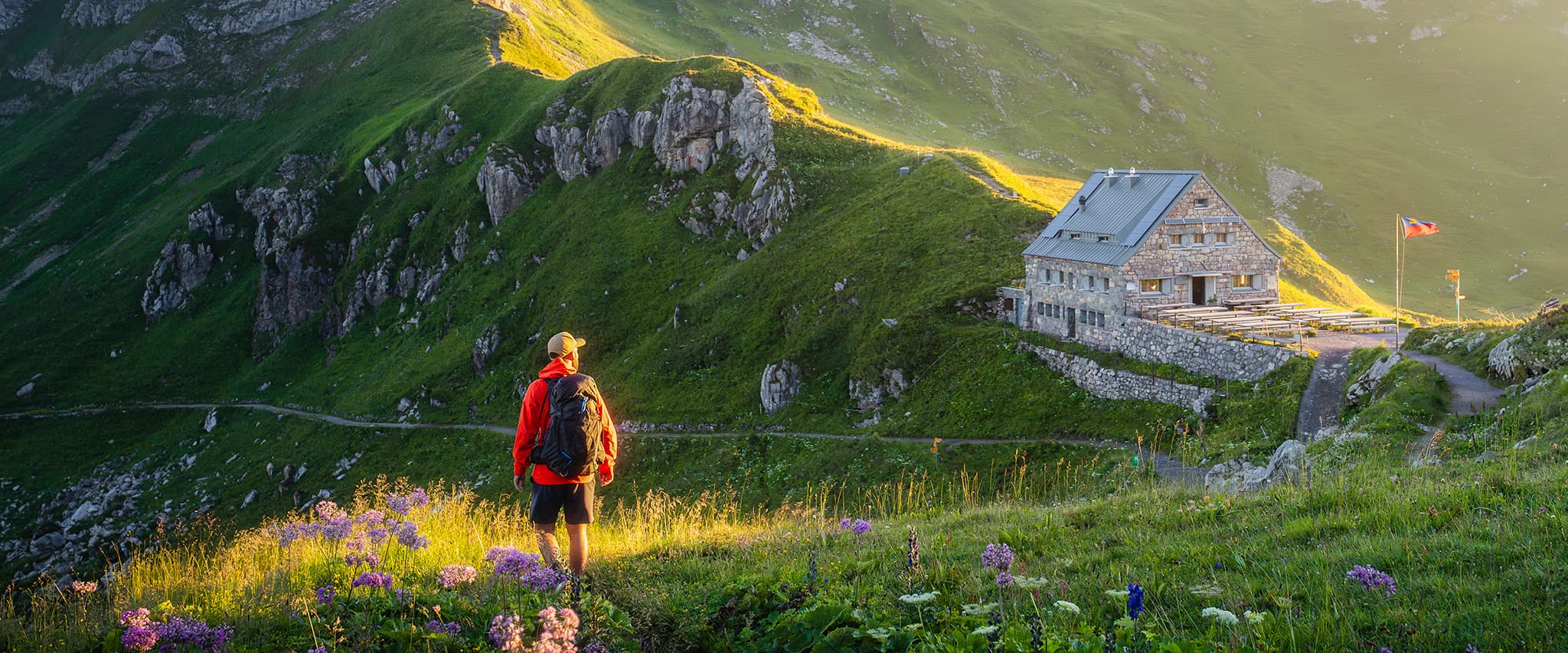 person hiking towards mountain hut