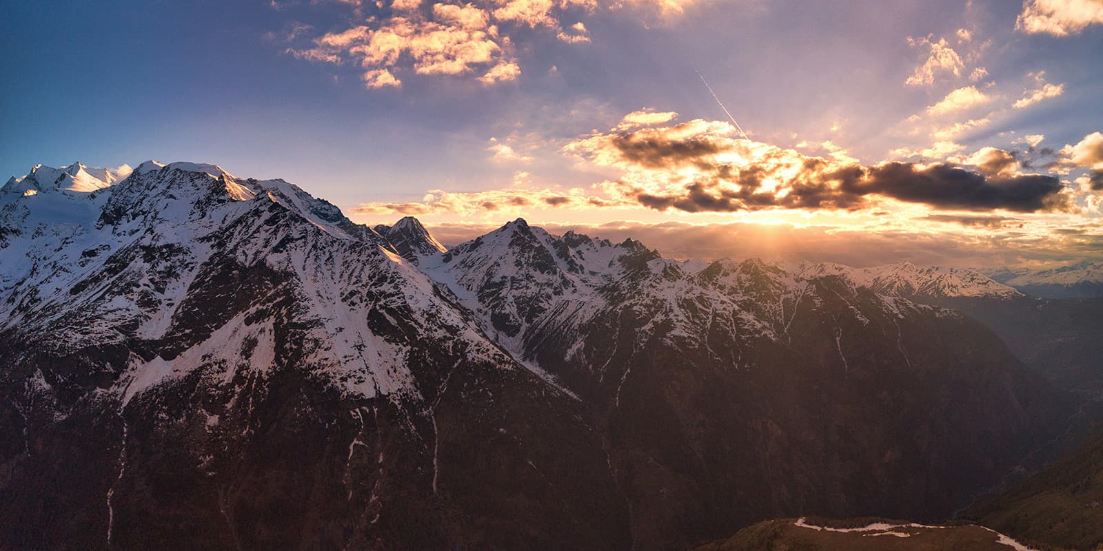 the sun is shining through the clouds over the swiss mountains