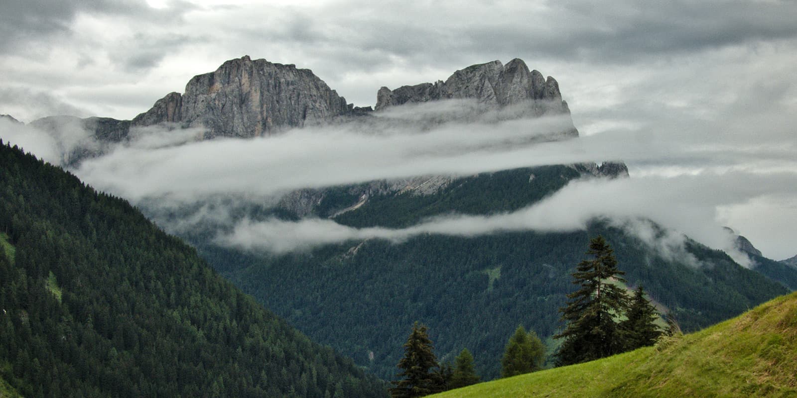 clouds covering mountains in the dolomites