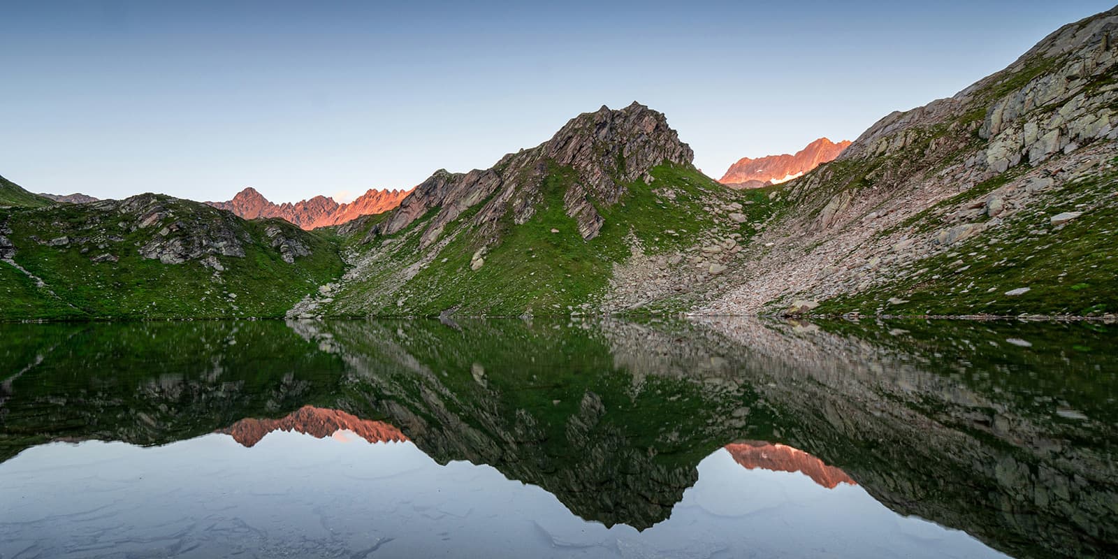 sunrise in the swiss alps with reflection in mountain lake