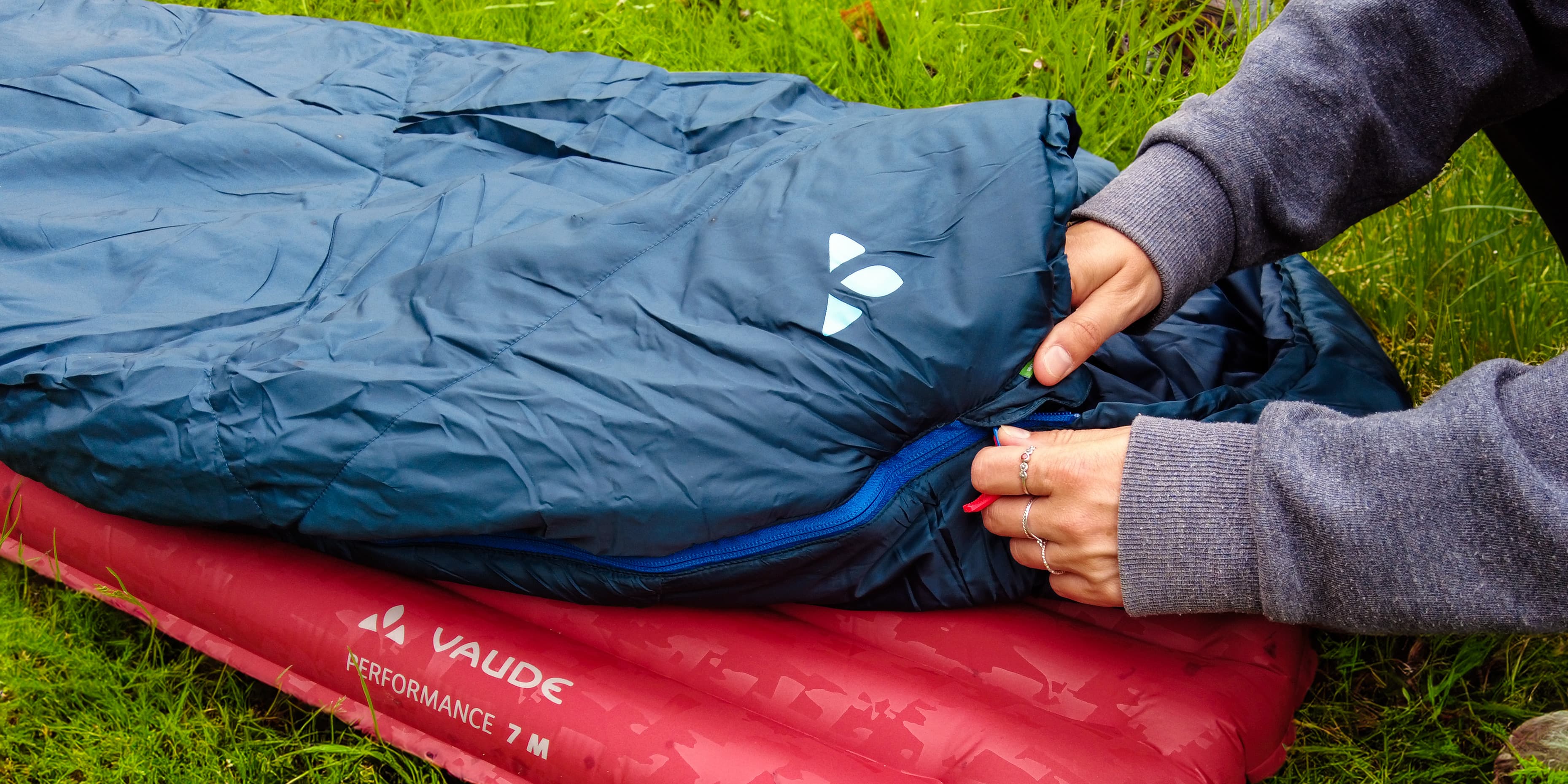 person zipping their Vaude sleeping bag