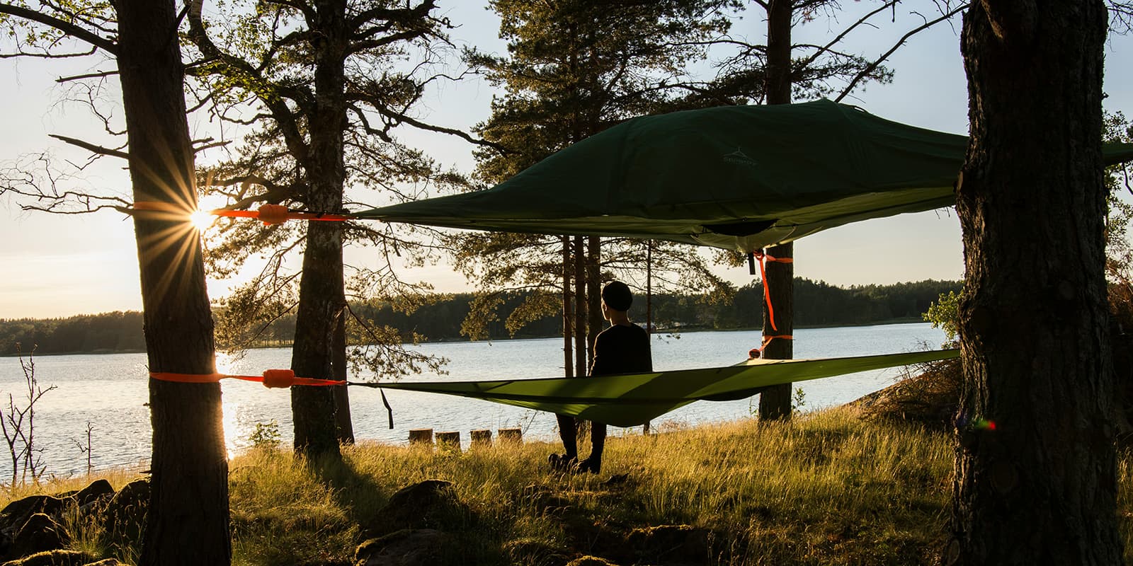 person in hammock overlooking a lake