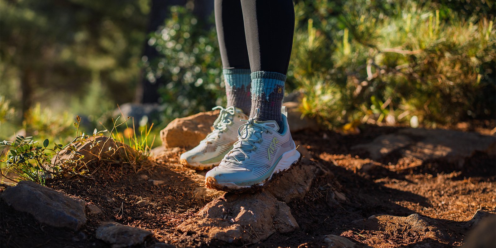 person standing on rocks wearing Lowa Madrix Ws shoes