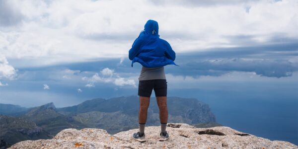 person in RAB waterproof jacket standing on top of mountain