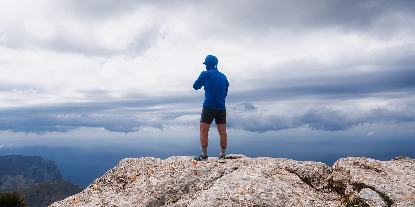 person in RAB waterproof jacket standing on top of mountain