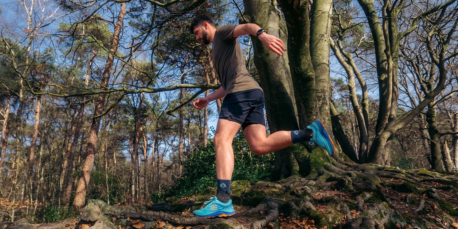 person trail running in forest