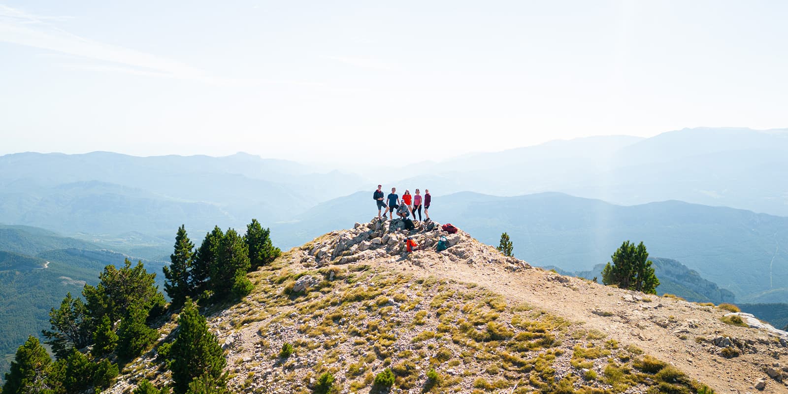 group of hikers posing on top of a mountain in the Catalan Pyrenees