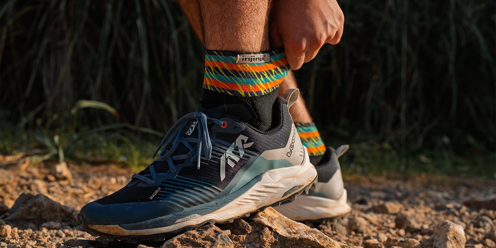 person adjusting his Injinji socks and wearing LOWA shoes