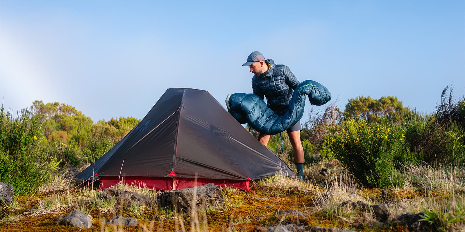 person putting his thermarest sleeping bag in MSR tent
