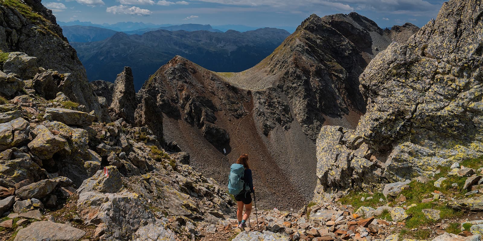 person with Deuter backpack standing on mountain pass