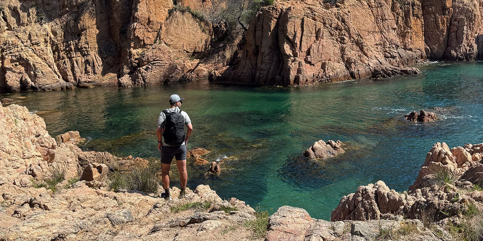 person on cliff near the sea on the Camí de Ronda
