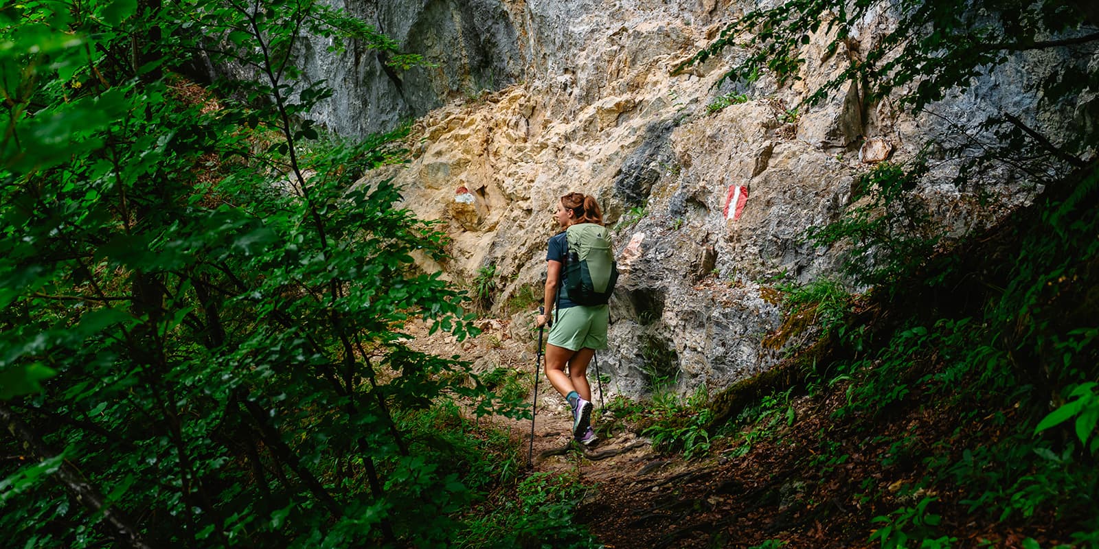 women hiking on small forest path wearing Deuter Futura backpack