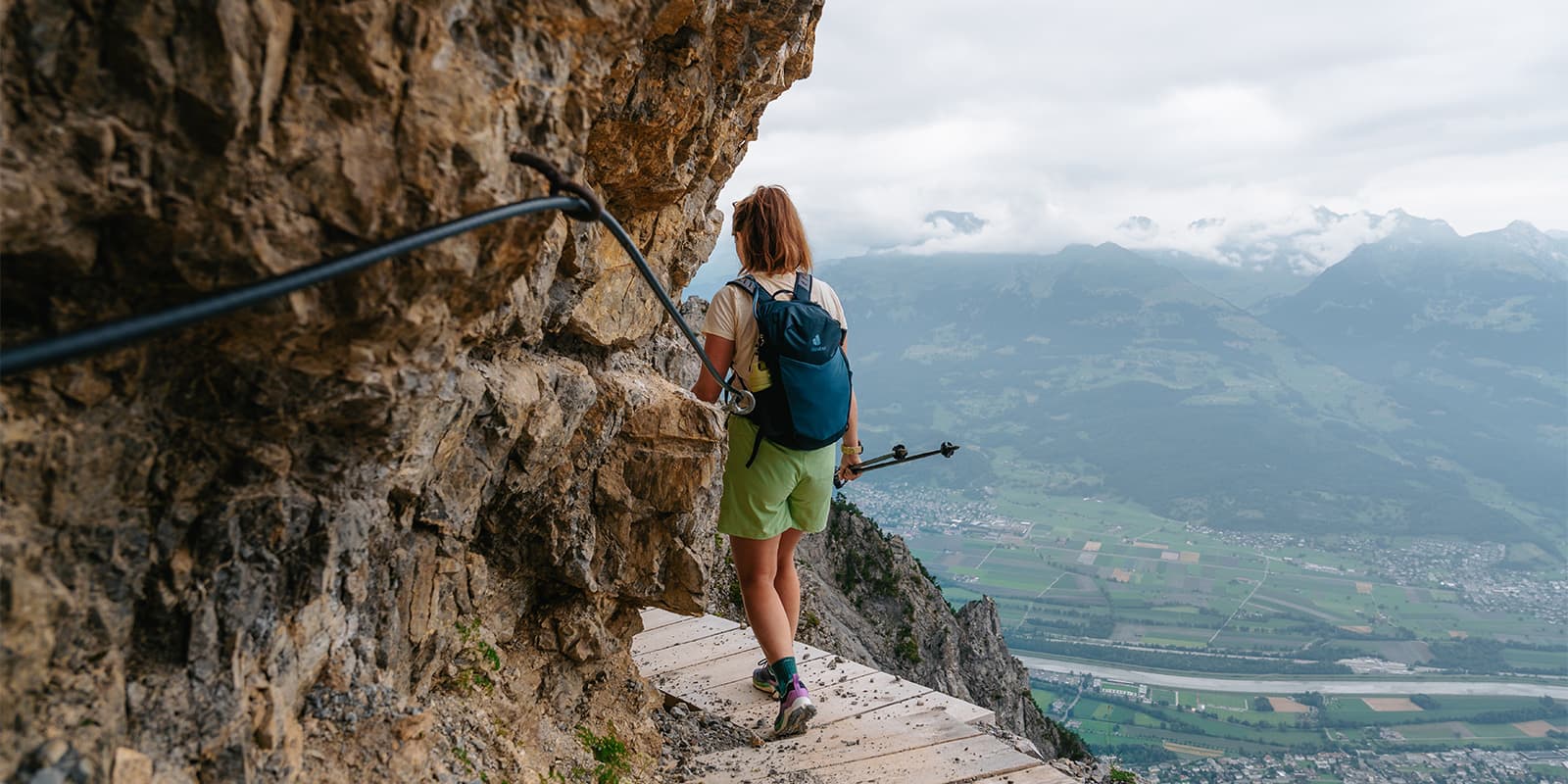 person hiking on narrow wooden walkway on the Fürstensteig in Liechtenstein wearing a Deuter Speed Lite backpack