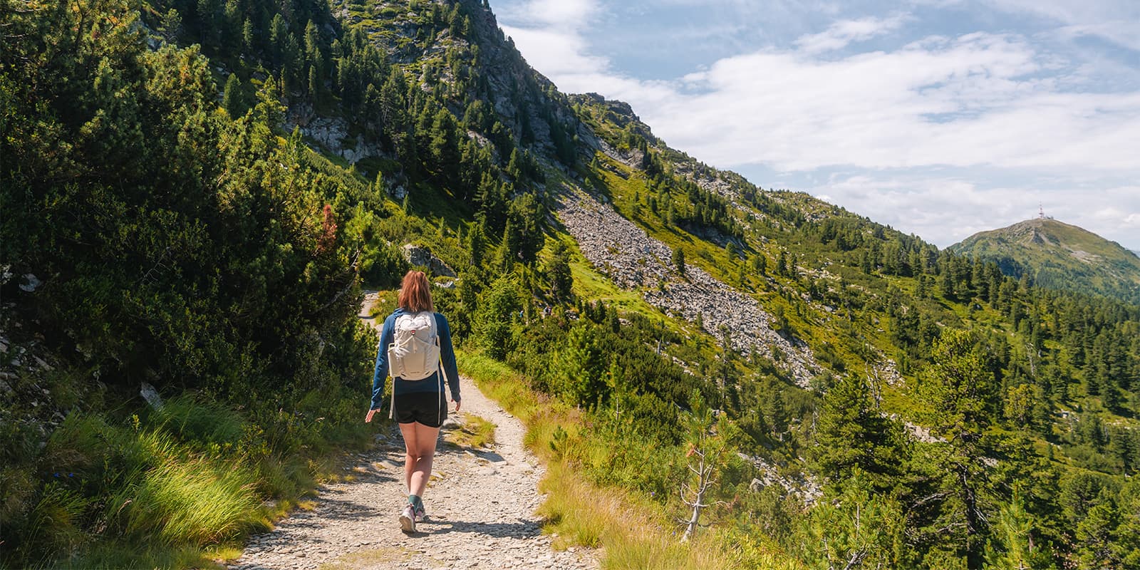 person hiking on the Zirbenweg overlooking the city of Innsbruck