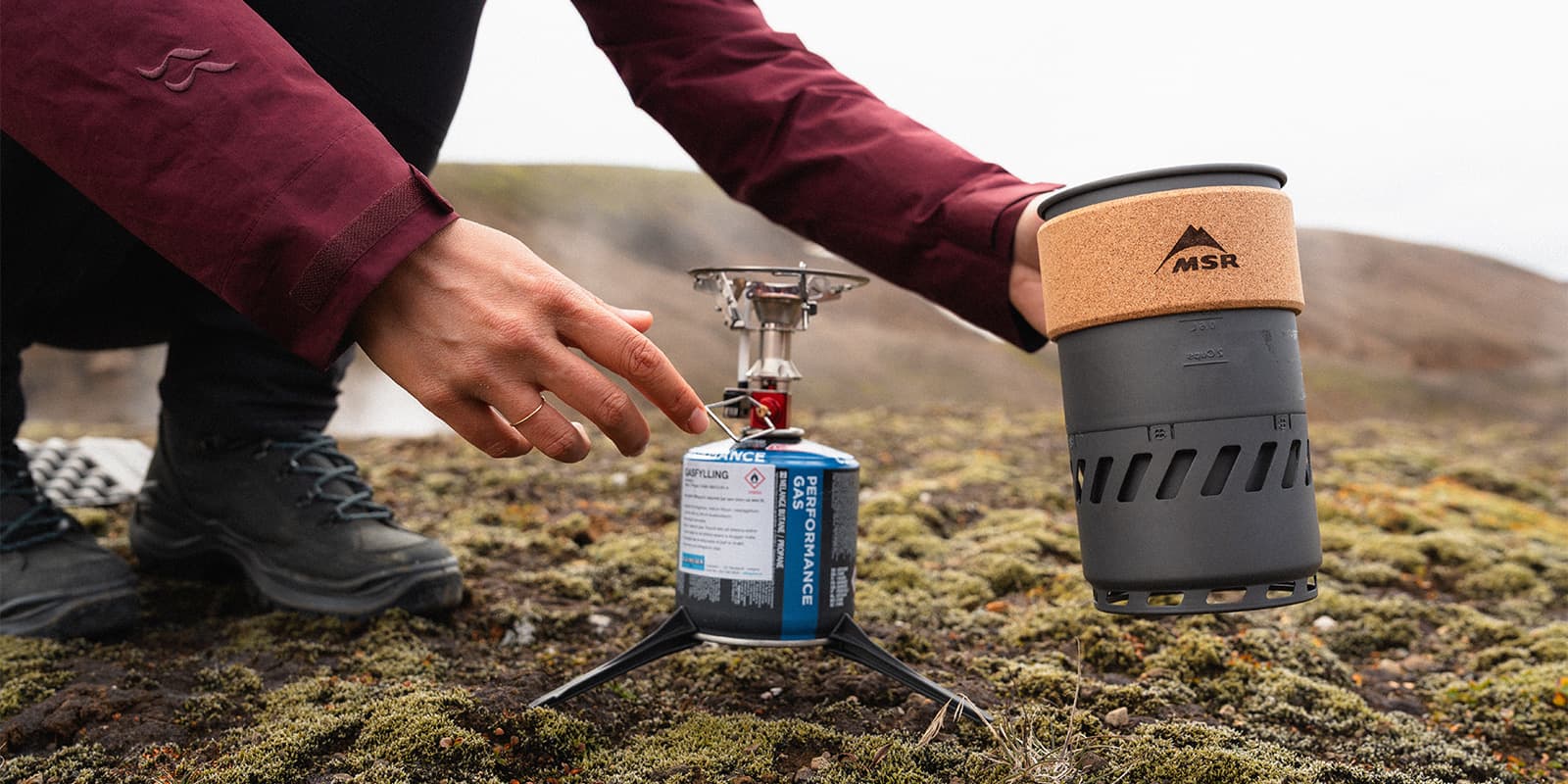 person cooking outdoor witch msr cooking stove