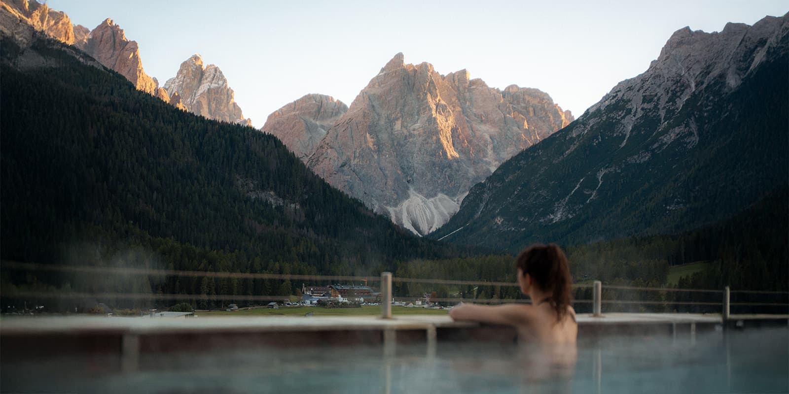 Person in hotel swimming pool looking at the Dolomites