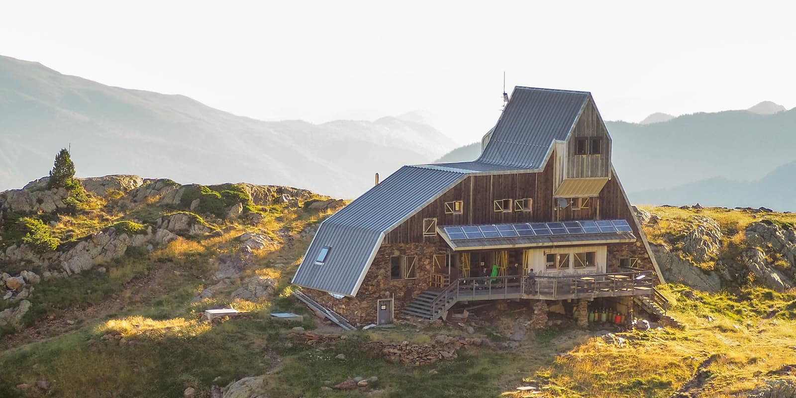 sunrise in the pyrenees with view of a mountain hut