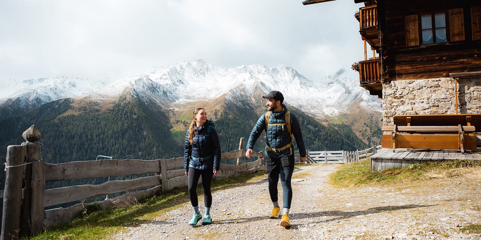 hikers on the Almweg 2000 with snow capped mountains in the background
