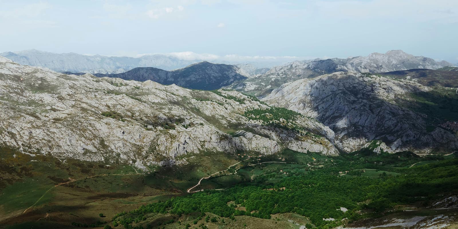 mountain range of Picos de Europa with green valley in the foreground